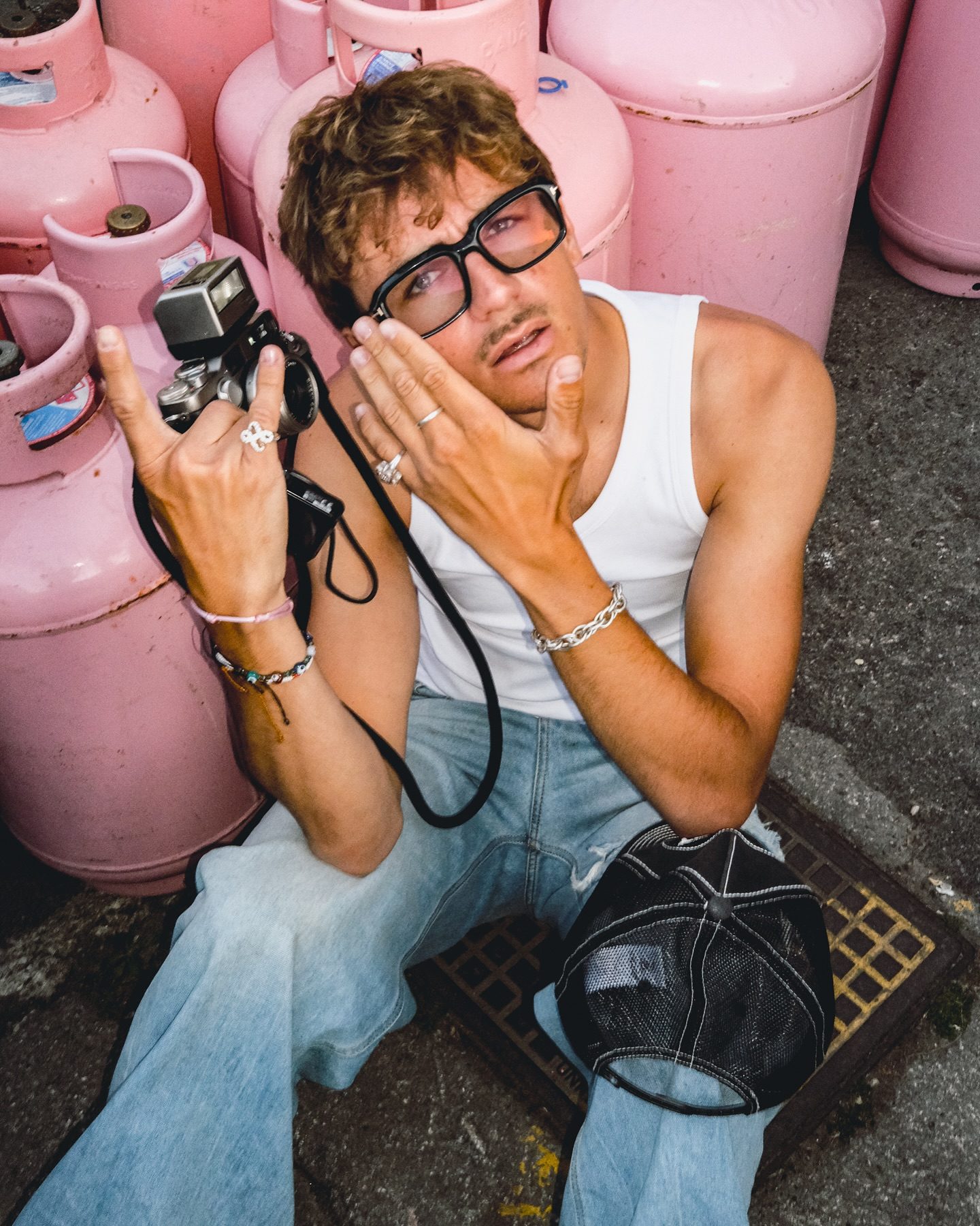 Photographer holding camera in front of pink cylinders